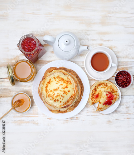 Pancake week  Maslenitsa concept. Pancakes  Cup of tea  teapot and sweets - honey  jam on wooden table. delicious Breakfast with Homemade Pancakes. flat lay