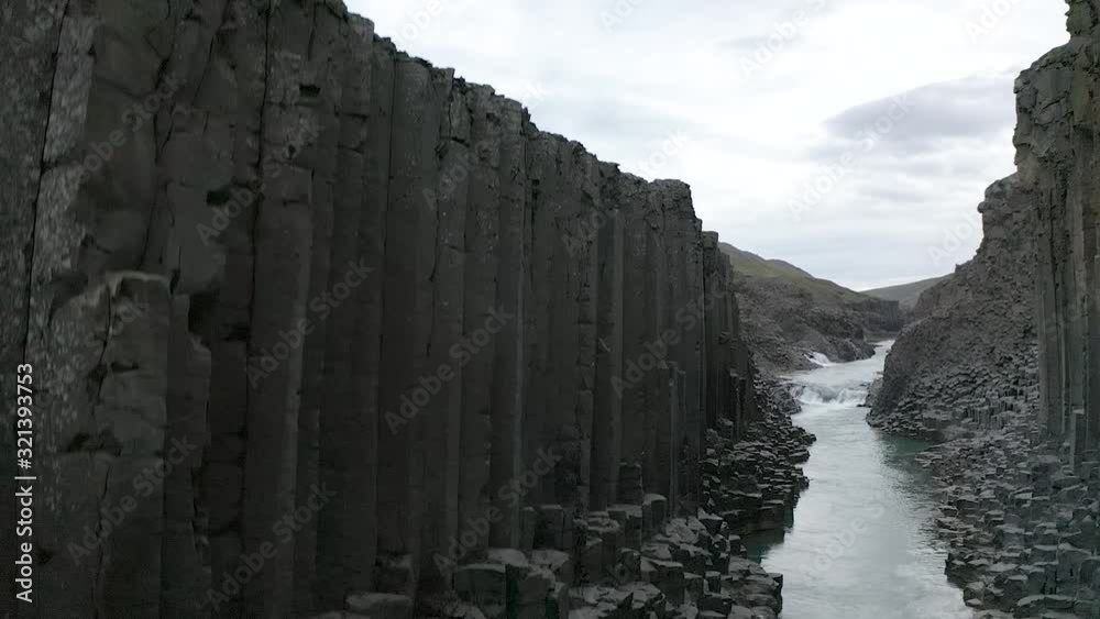 Aerial rising from bottom of canyon next to gigantic basalt columns revealing landscape in Iceland. Aerial rising from bottom of canyon next to gigantic basalt columns revealing landscape in Iceland.