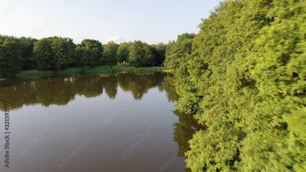 Airial view over lake Luetjensee, lakeshore, landscape and surrounding forest. Drone is approaching lakeshore. Airial view over lake Luetjensee, lakeshore, landscape and surrounding forest. Drone is approaching lakeshore.