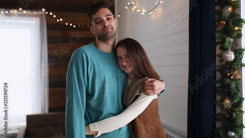 A happy couple hugs and look at the camera.