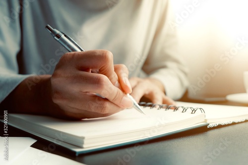 Asian woman is sitting and writing message in personal journal or diary as for remind vent some secret feeling, don't want anyone to know. Is way to cure stress, healing, reduce depression or suicide