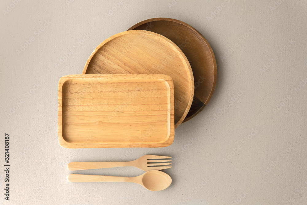 Top view empty wooden renewable bamboo serving plates and platters with cutlery eco friendly natural good for environmental climate change on grey color organic paper background. Top view empty wooden renewable bamboo serving plates and platters with cutlery eco friendly natural good for environmental climate change on grey color organic paper background.