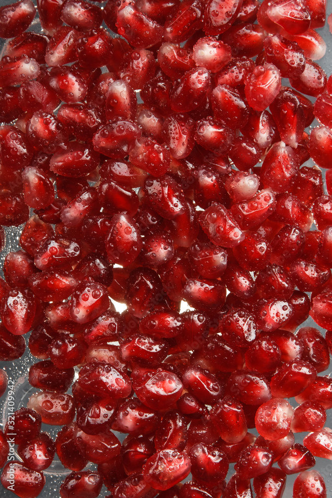 Pomegranate seeds with water drops. Texture for the background. Ripe berries of pomegranate. Red texture of the granules in the macro. Pomegranate seeds with water drops. Texture for the background. Ripe berries of pomegranate. Red texture of the granules in the macro.