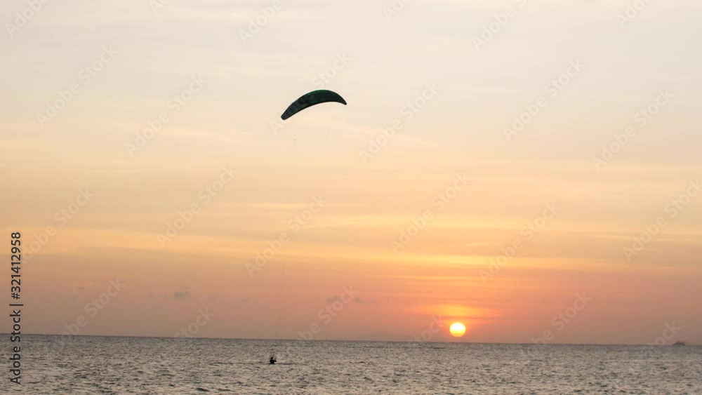 Sunset on the ocean, kite surfers ride on the sea Sunset on the ocean, kite surfers ride on the sea