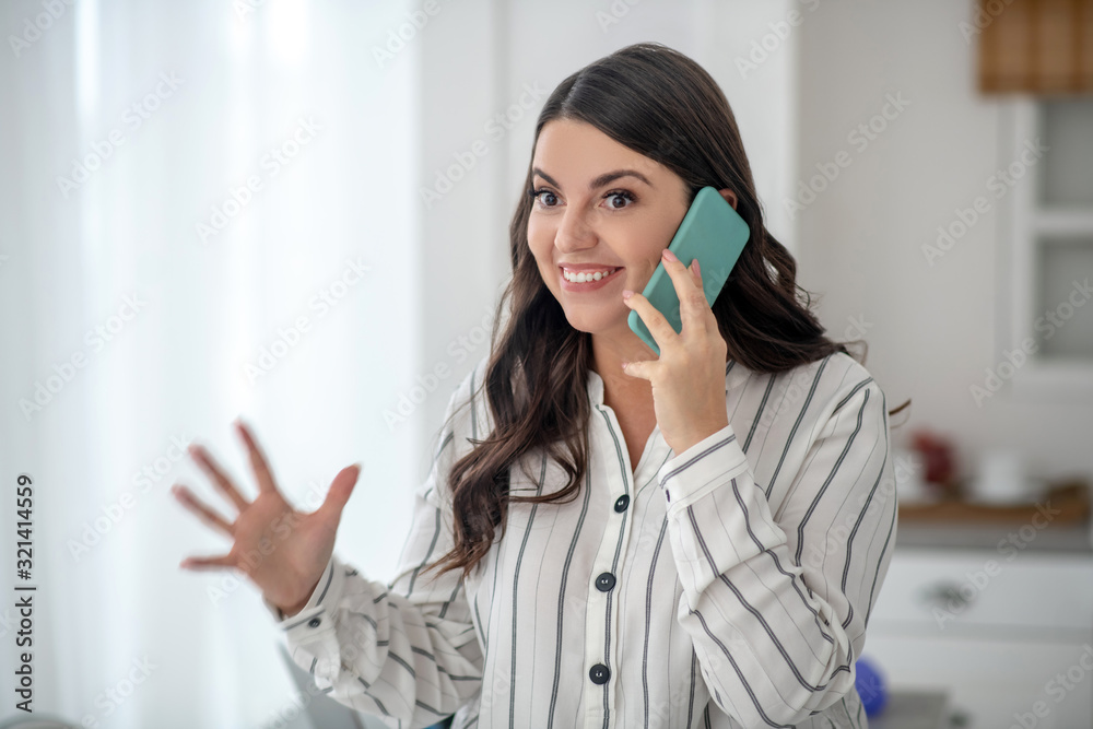 Long-haired woman in a striped blouse looking enthusiastic Long-haired woman in a striped blouse looking enthusiastic