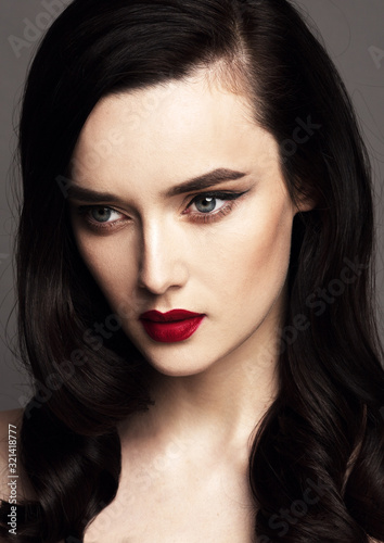 Close-up portrait of beautiful model with long dark hair and bright make up