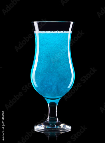 Blue curacao cocktail in hurricane glass isolated on black background