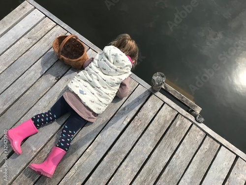 Little girl looking into pond water