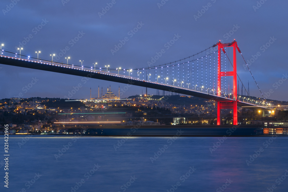 Dusk over the First Bosporus Bridge Crossing the Bosphorus or Bosporus Straits Istanbul Turkey. Büyük Çamlıca Camii Mosque and Beylerbeyi  Palace are visible .