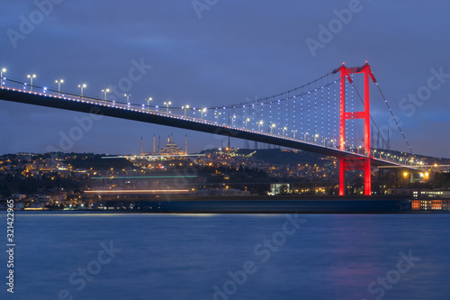 Dusk over the First Bosporus Bridge Crossing the Bosphorus or Bosporus Straits Istanbul Turkey. Büyük Çamlıca Camii Mosque and Beylerbeyi Palace are visible .