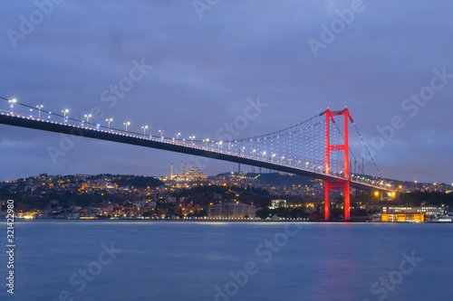 Dusk over the First Bosporus Bridge Crossing the Bosphorus or Bosporus Straits Istanbul Turkey. Büyük Çamlıca Camii Mosque and Beylerbeyi Palace are visible .