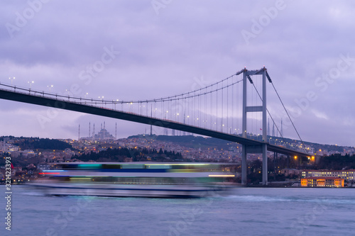  Sunset or Dusk over the First Bosporus Bridge Crossing the Bosphorus or Bosporus Straits Istanbul Turkey. Büyük Çamlıca Camii Mosque and Beylerbeyi Palace are visible .