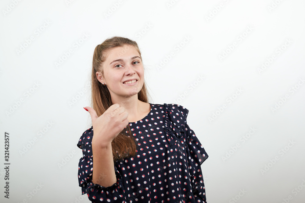 Fair-haired beautiful girl in a black dress with white circles happy smiling gave thumbs up Fair-haired beautiful girl in a black dress with white circles happy smiling gave thumbs up