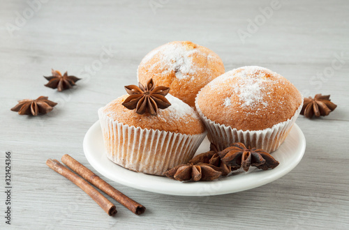 Tasty muffins on a plate ready to eat. Cinnamon sticks and star anise.