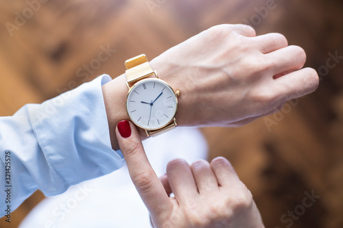 Young woman checking the time on watch photo