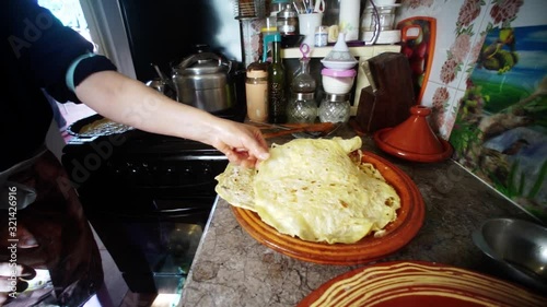 The most traditional Moroccan dishes. Moroccan woman put the cooked bread on a large traditional bowl.  making Rfissa