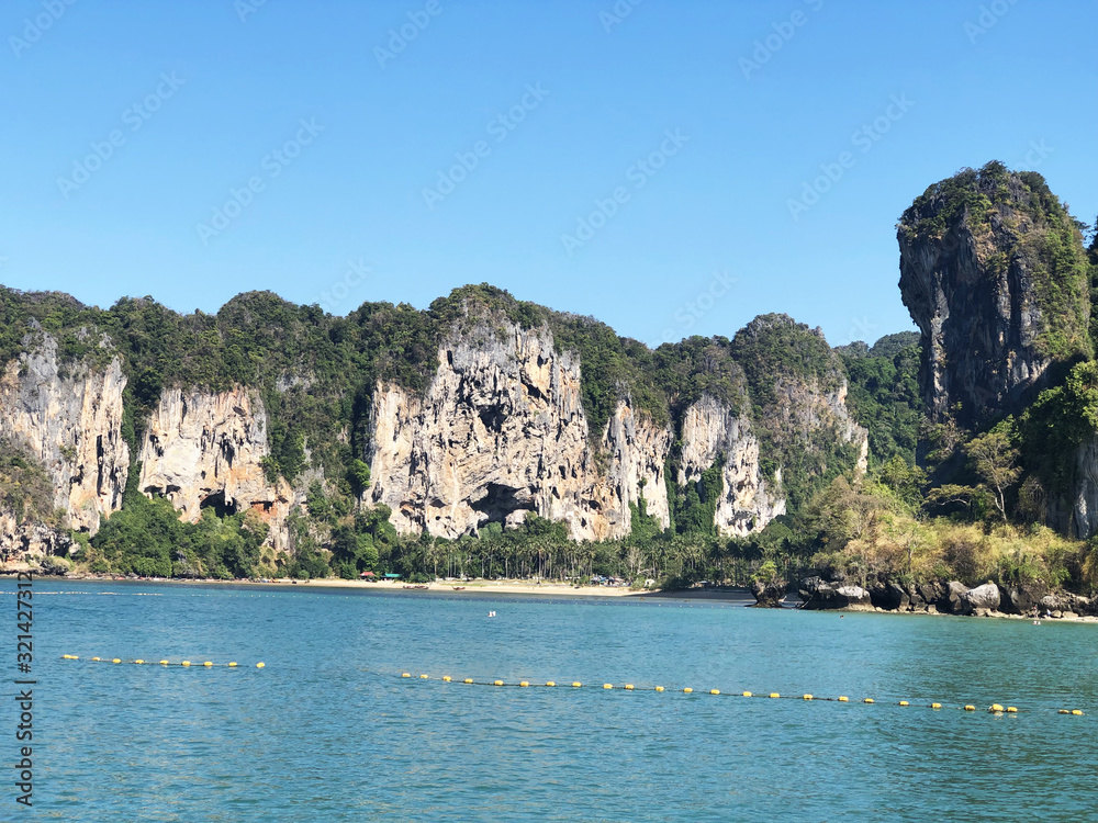 Aonang, Krabi / Thailand - February 11, 2019: Aonang Beach, the beautiful and famous place in Thailand, blue sky and green sea with mountains, good for the vacation season.