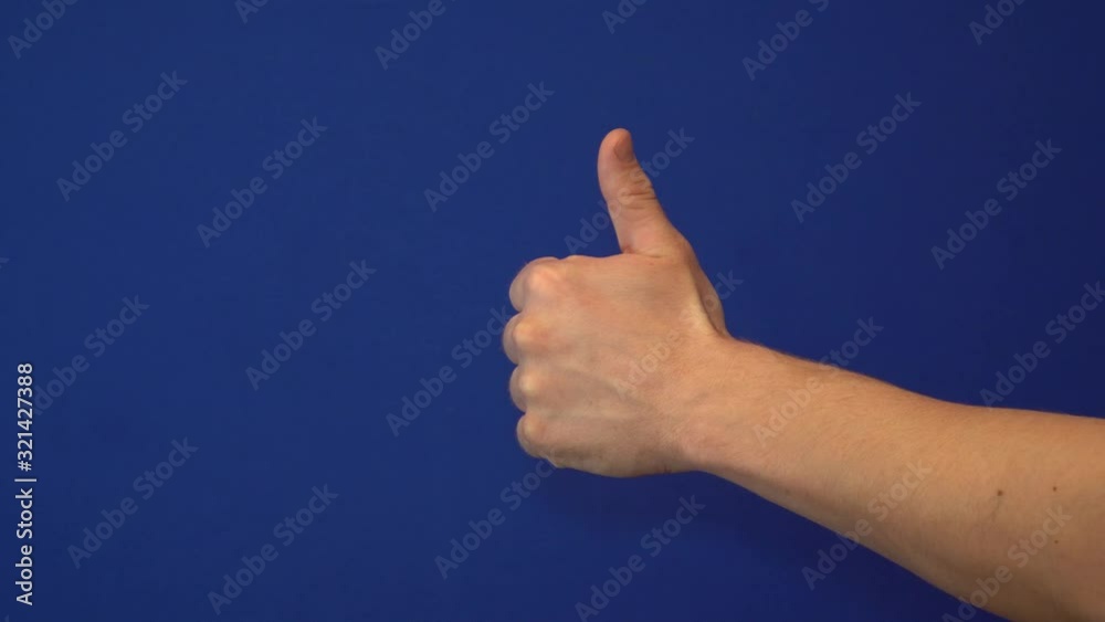 Hand on blue background shows a fist with the thumb to the top Hand on blue background shows a fist with the thumb to the top