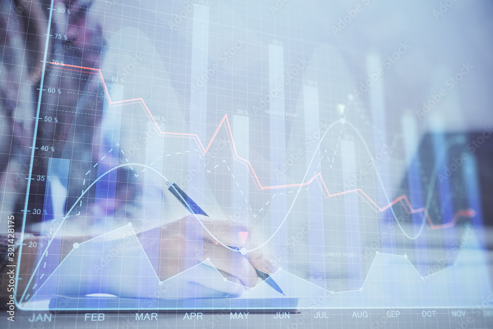 A woman hands writing information about stock market in notepad. Forex chart holograms in front. Concept of research. Double exposure A woman hands writing information about stock market in notepad. Forex chart holograms in front. Concept of research. Double exposure