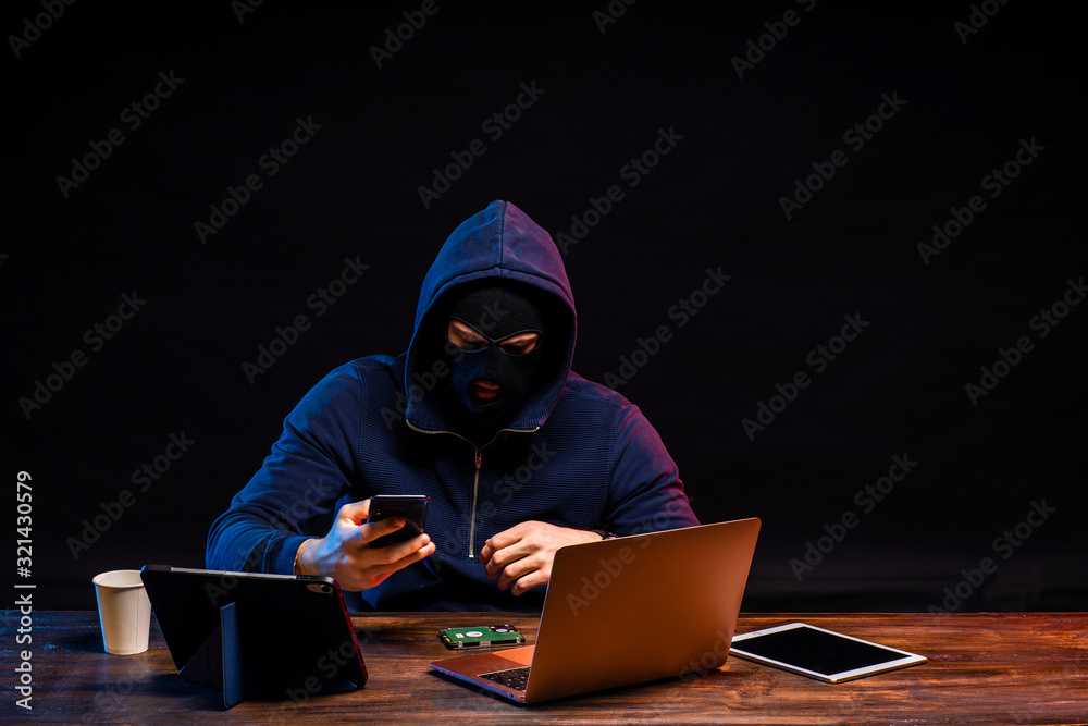 young dangerous hacker bandit engaged in crime, don't afraid of strangers, entered the room and hack laptop system, password. cyberattack nowadays. isolated in dark smoky space young dangerous hacker bandit engaged in crime, don't afraid of strangers, entered the room and hack laptop system, password. cyberattack nowadays. isolated in dark smoky space
