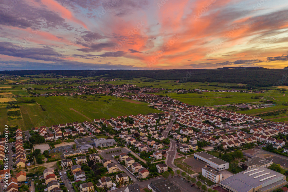 Drone view of Dijon townscape under colorful sky at dusk