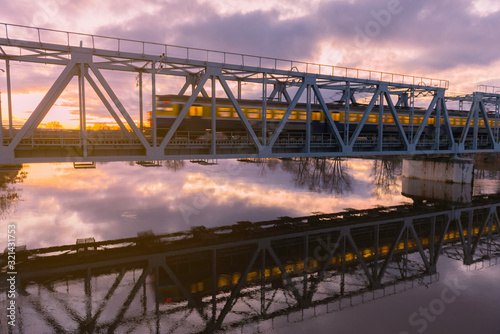 train going across bridge at sunrise © Sindija