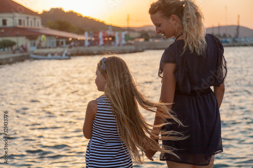 Mother and the girl child in the seafront on the sunset, Hvar, Croatia