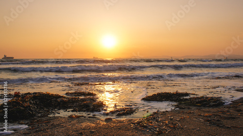 Sunset sea horizon cargo ship silhouette landscape.