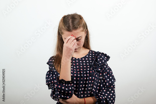 Fair-haired beautiful girl in a black dress with white circles upset in despair bowed her head and sad