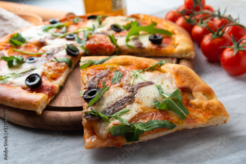 Deliziosa pizza con rucola, acciughe e olive 