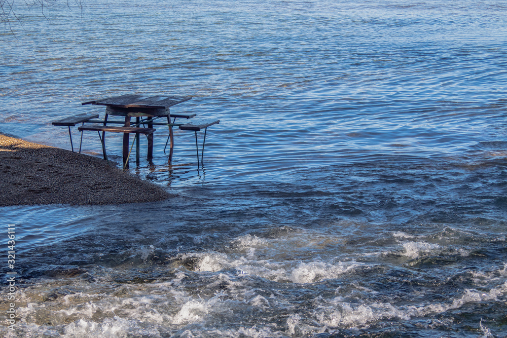 A lonely table in the water. Where the lush waters of the springs flow into the lake. Winter mood. Ohrid Lake, Northern Macedonia. A lonely table in the water. Where the lush waters of the springs flow into the lake. Winter mood. Ohrid Lake, Northern Macedonia.