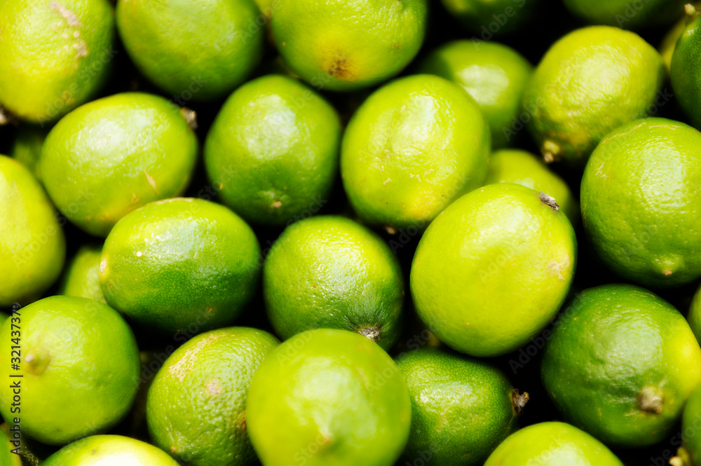 Fresh green lemon lime texture background / pile of lime for sale in the market Fresh green lemon lime texture background / pile of lime for sale in the market