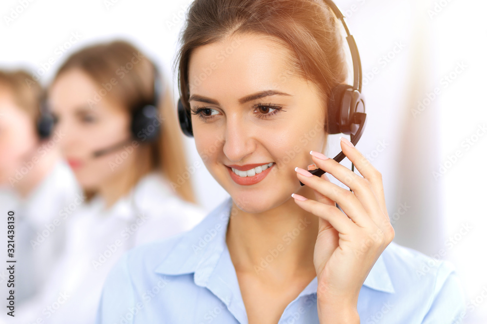 Call center. Focus on beautiful business woman using headset in sunny office Call center. Focus on beautiful business woman using headset in sunny office