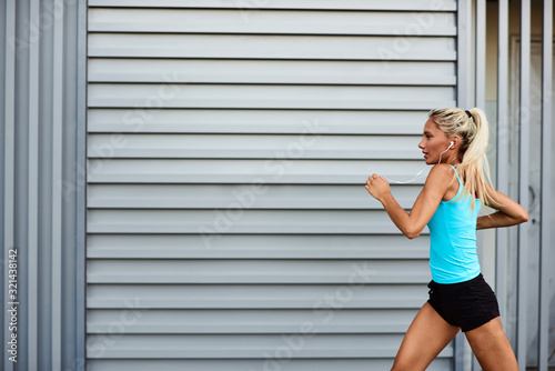 Modern sportswoman jogging in the urban area.