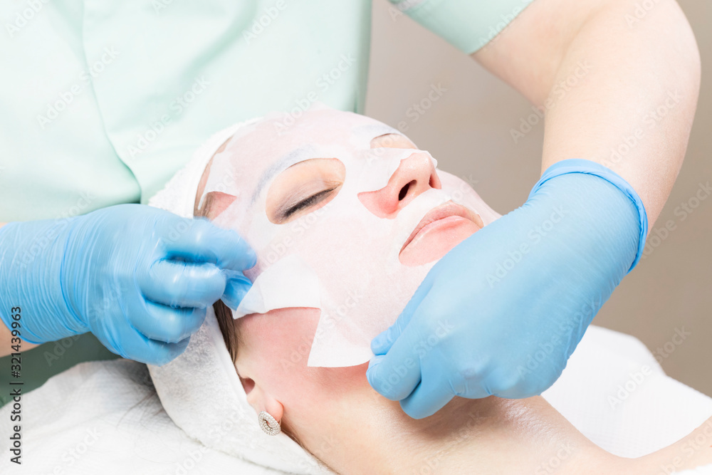 Fototapeta premium Procedure female cosmetic mask and chistak face in a beauty salon.