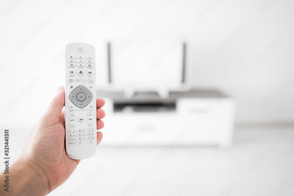 Hand holding TV remote controller with a modern television set. Hand holding TV remote controller with a modern television set.