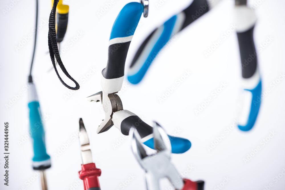 Selective focus of pliers and soldering iron levitating in air isolated on white Selective focus of pliers and soldering iron levitating in air isolated on white