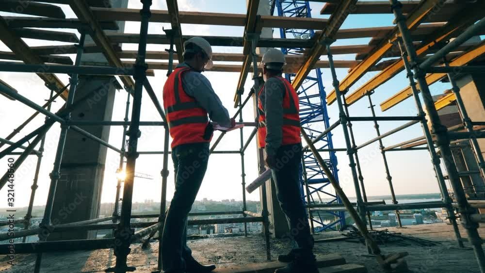 People work with blueprints in a building on a site. People work with blueprints in a building on a site.