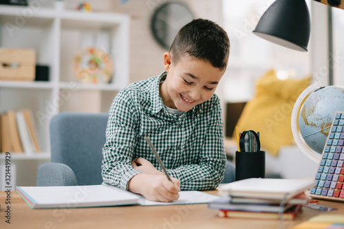 Cute little boy doing homework. Child learning foe school.