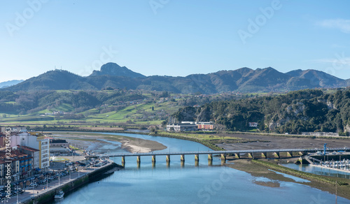 Aerial view landscape of Ribadesella port town, in  Principado de Asturias, Spain. The centered bridge crossing the Sella river and mountains in the background. photo