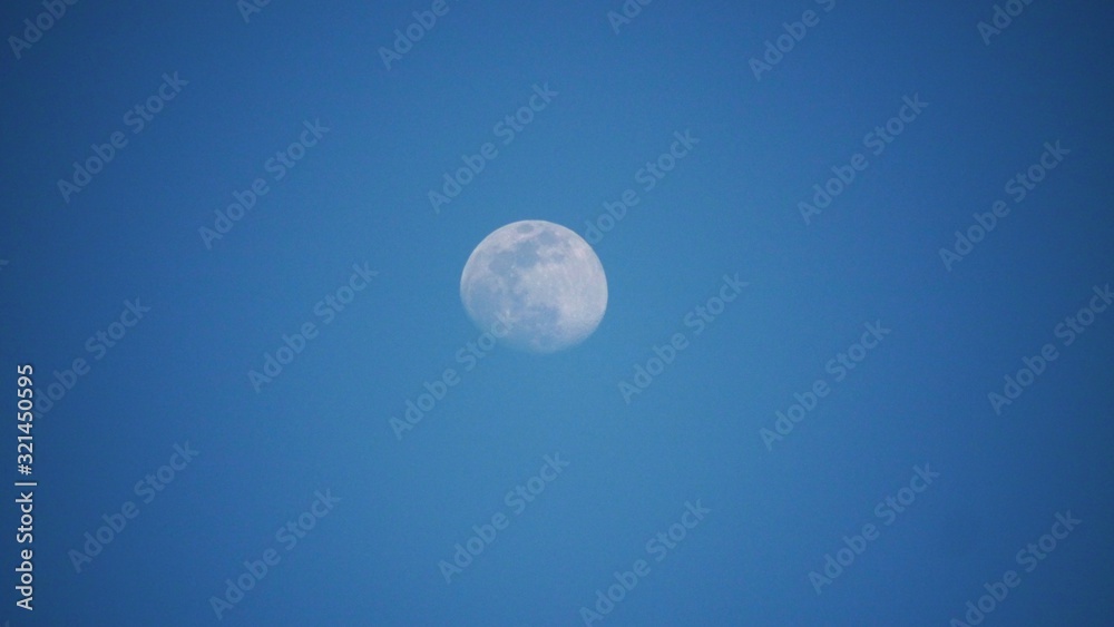 Waxing moon with wide blue skies in the background Waxing moon with wide blue skies in the background