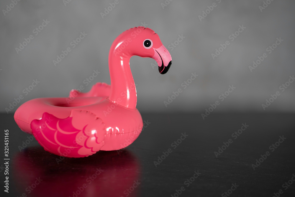 Fototapeta Pink inflatable Flamingo on a gray background, pool float party