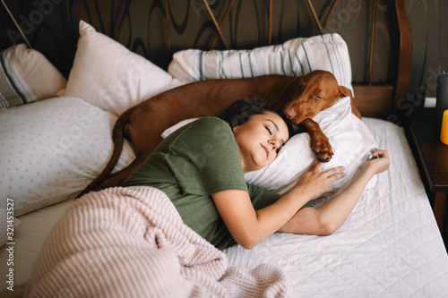 Girl with dog in bed. Best friends sleeping together.