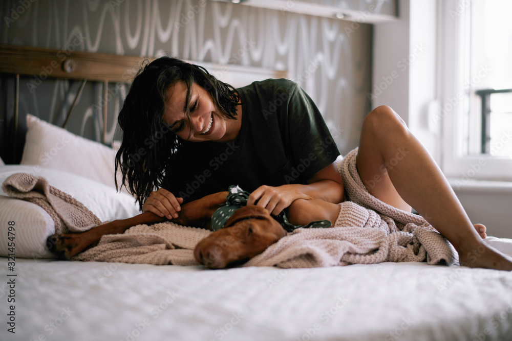 Girl with dog in bed. 