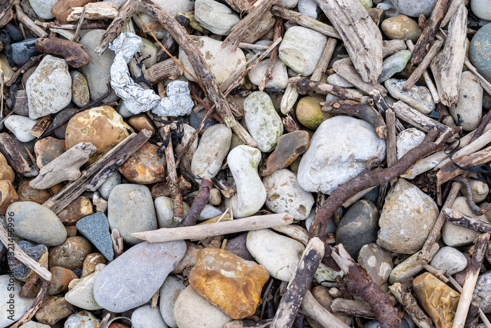 Close up detail shot of various stones and pebbles interspersed with branches and twigs. Taken near the coastline of Roker in Sunderland. Close up detail shot of various stones and pebbles interspersed with branches and twigs. Taken near the coastline of Roker in Sunderland.