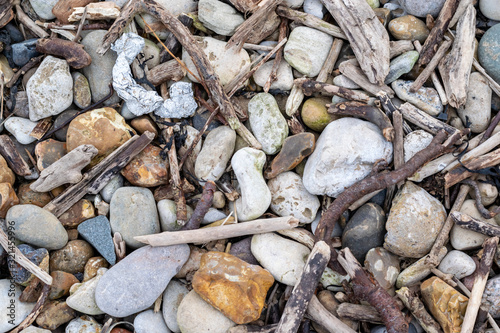 Close up detail shot of various stones and pebbles interspersed with branches and twigs. Taken near the coastline of Roker in Sunderland.