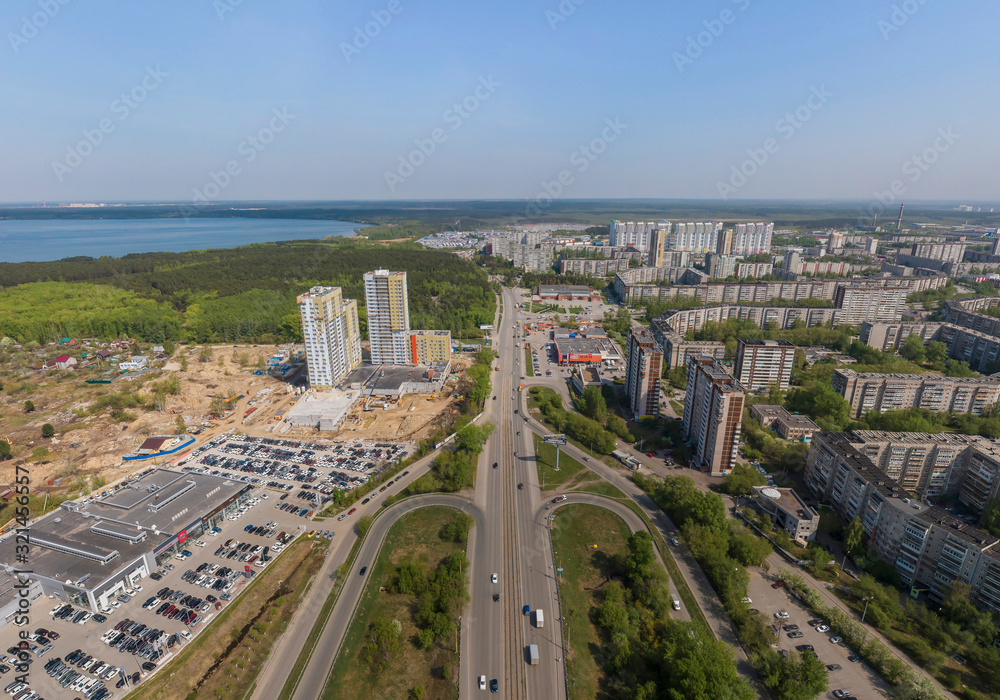 ZHBI district, Shartash lake and multi-apartment buildings under construction in Yekaterinburg city, Russia. Aerial, summer, sunny