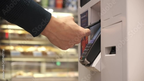 a young man buys a telephone in a contactless way in a self-service machine. men pay by phone. close up. 4k Video 