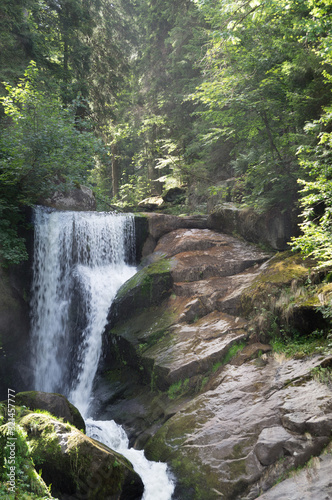 Fototapeta Naklejka Na Ścianę i Meble -  View of a waterfall flowing over a rock edge.