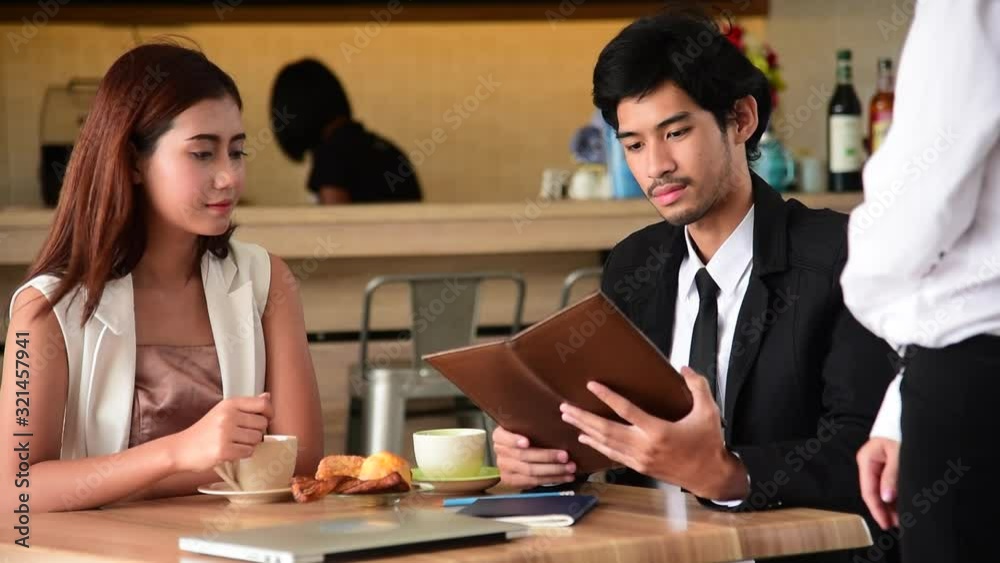 Customer use credit card payment for food at restaurant. Young couple checkout bill and pay via credit to cashier nfc contactless machine. Customer use credit card payment for food at restaurant. Young couple checkout bill and pay via credit to cashier nfc contactless machine.